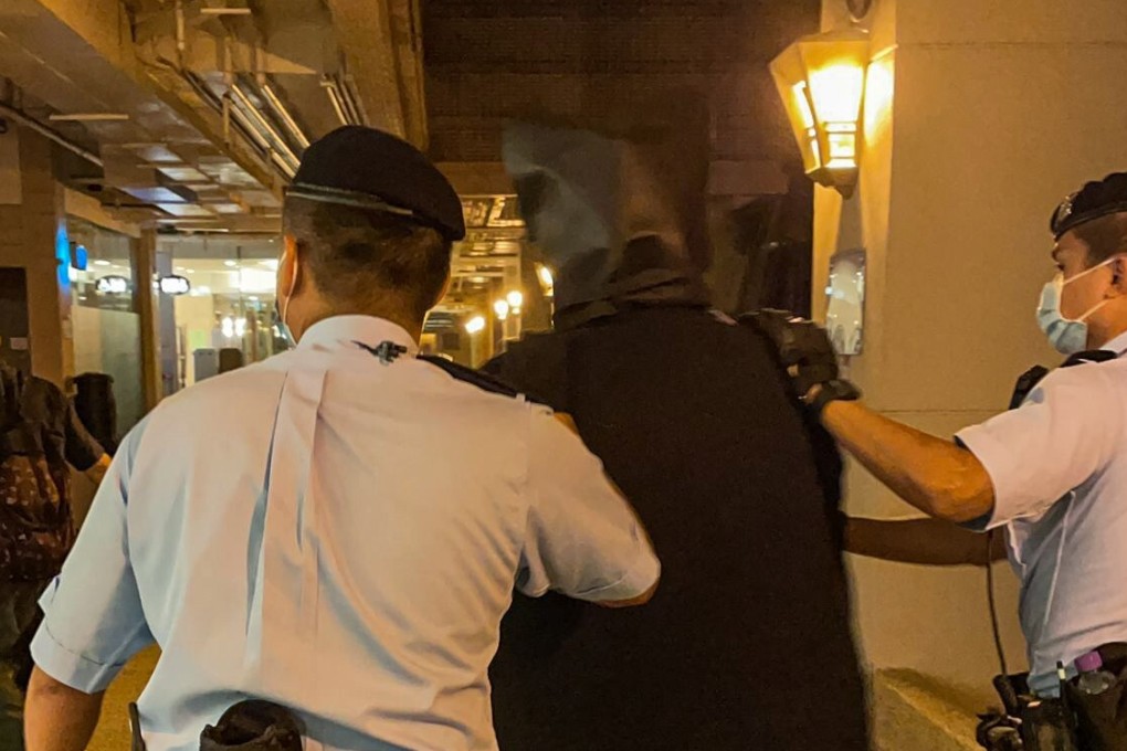 A suspect is escorted by police out of a New Territories housing estate after a raid on a flat there on Monday night resulted in seven arrests. Photo: Handout