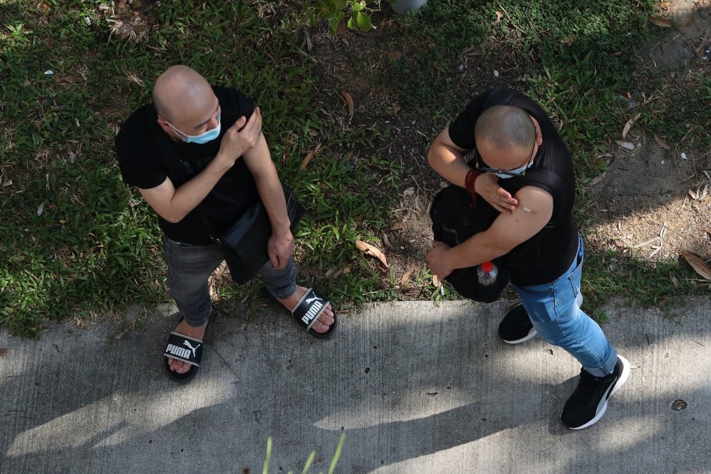 Two men wait outside a clinic after receiving the China-made Covid-19 Sinovac vaccine in Singapore. Photo: Getty Images