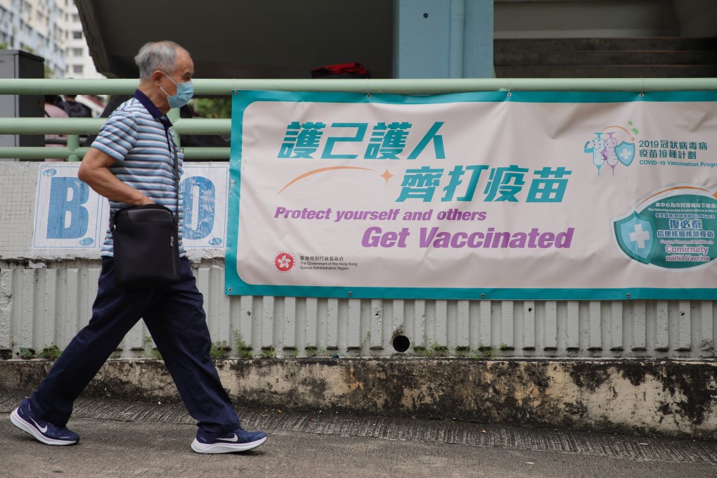 A man walks past a sign urging people to get vaccinated outside the Hiu Kwong Street Sports Centre in Kwun Tong. Photo: Winson Wong