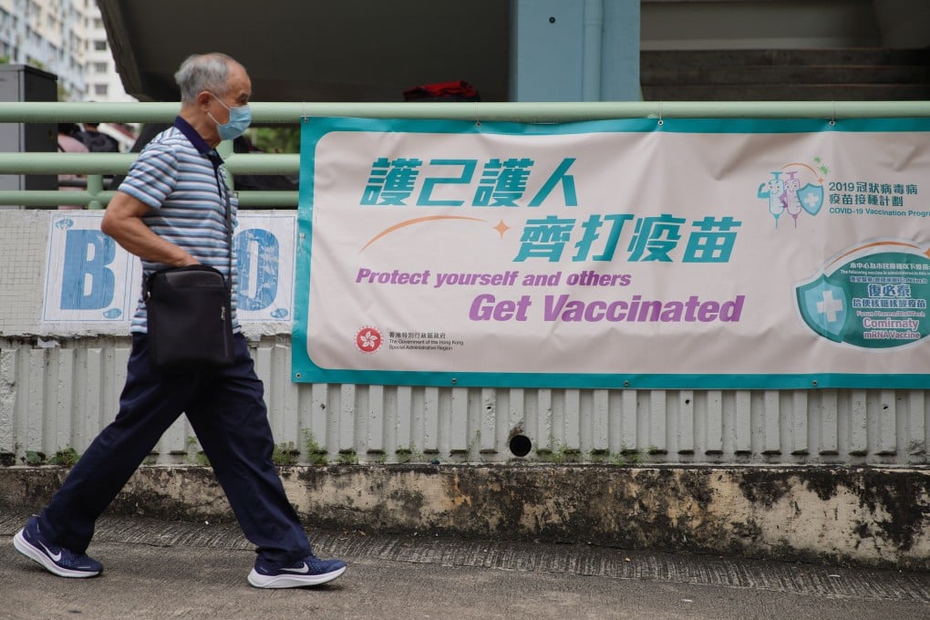 A man walks past a sign urging people to get vaccinated outside the Hiu Kwong Street Sports Centre in Kwun Tong. Photo: Winson Wong
