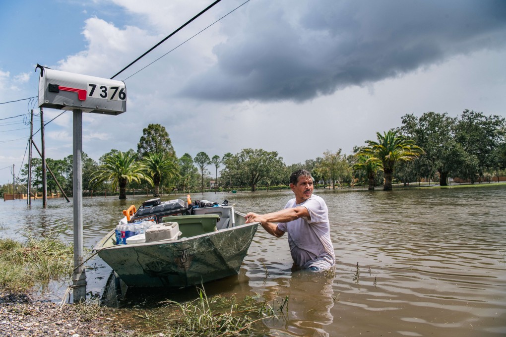 A man pulls a boat through a flooded neighbourhood in Barataria, Louisiana on Tuesday. Photo: AFP
