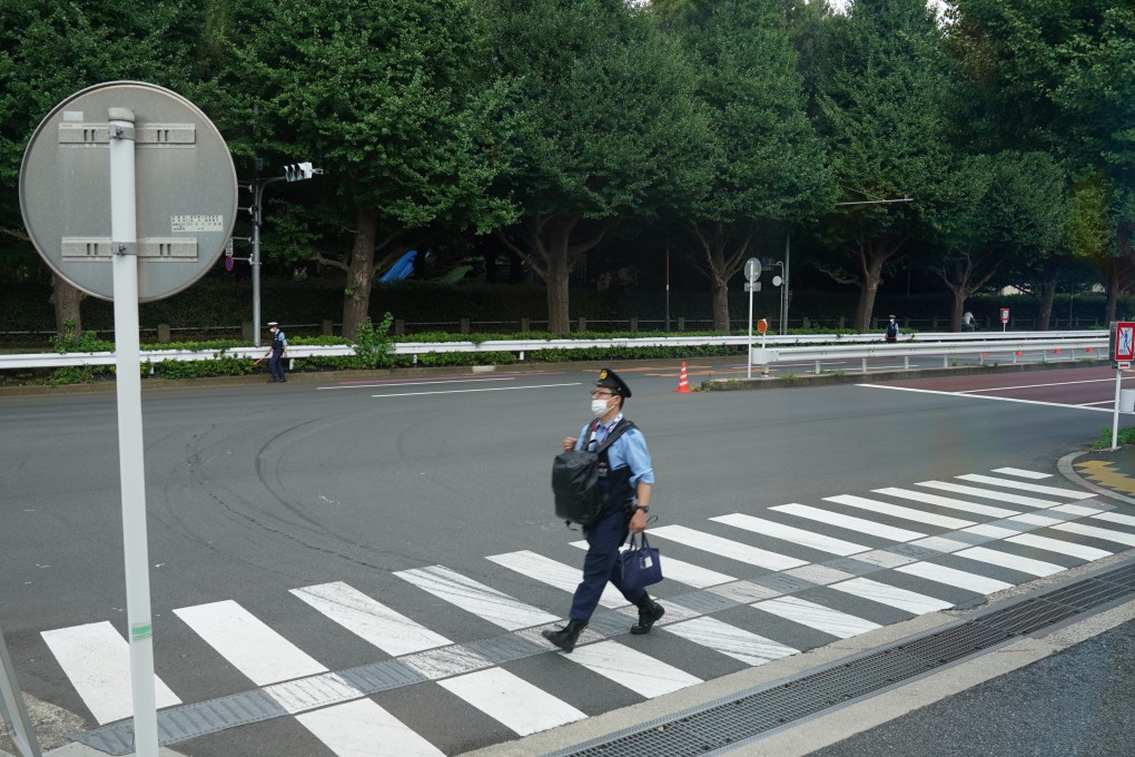 A Japanese police officer walks across a road outside the Olympic Stadium in Tokyo. A group of officers from Yamanashi have been relieved of their duties during the Paralympics for bad behaviour. Photo: DPA
