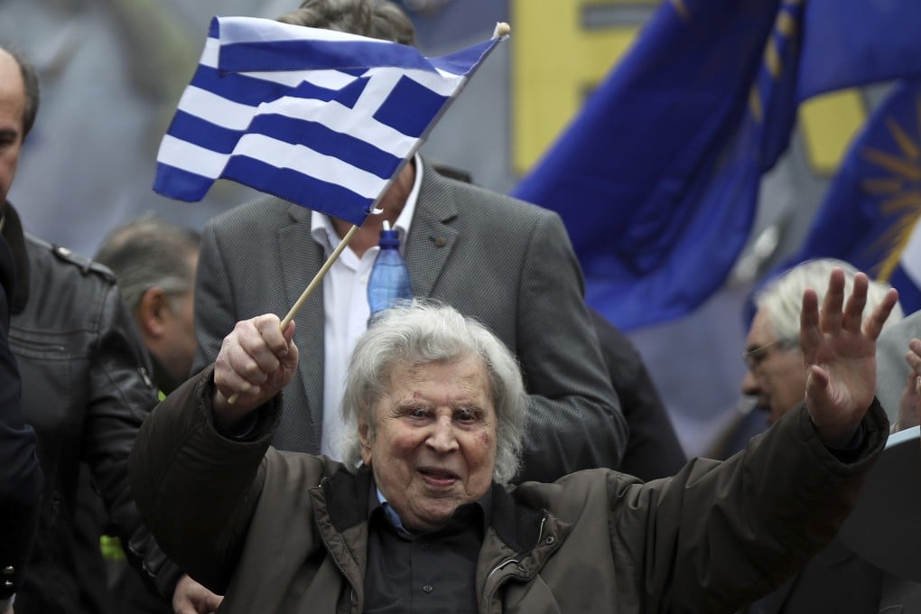 Greek composer Mikis Theodorakis waves a Greek flag at a rally in Athens, Greece in 2018. Photo: AP