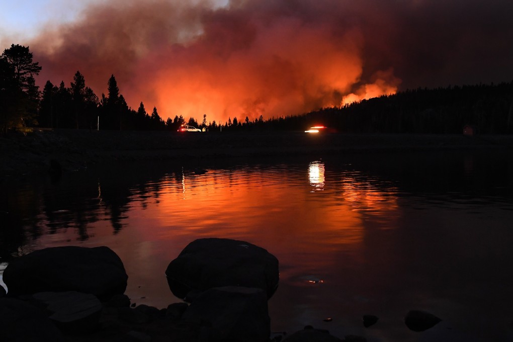 The Caldor fire is reflected off of Caples Lake near the Kirkwood ski resort in Lake Tahoe, California. Photo: Los Angeles Times / TNS