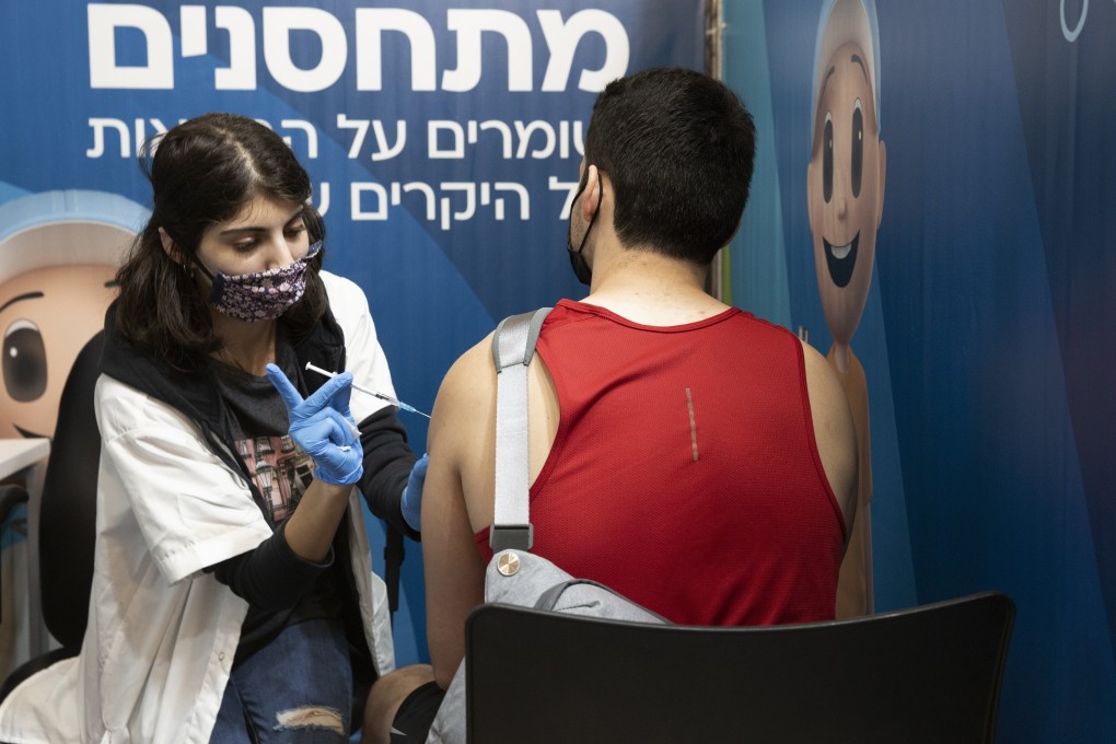 An Israeli man receives a booster shot of the coronavirus vaccine at the Cinema City complex in Jerusalem, Israel. Photo: AP