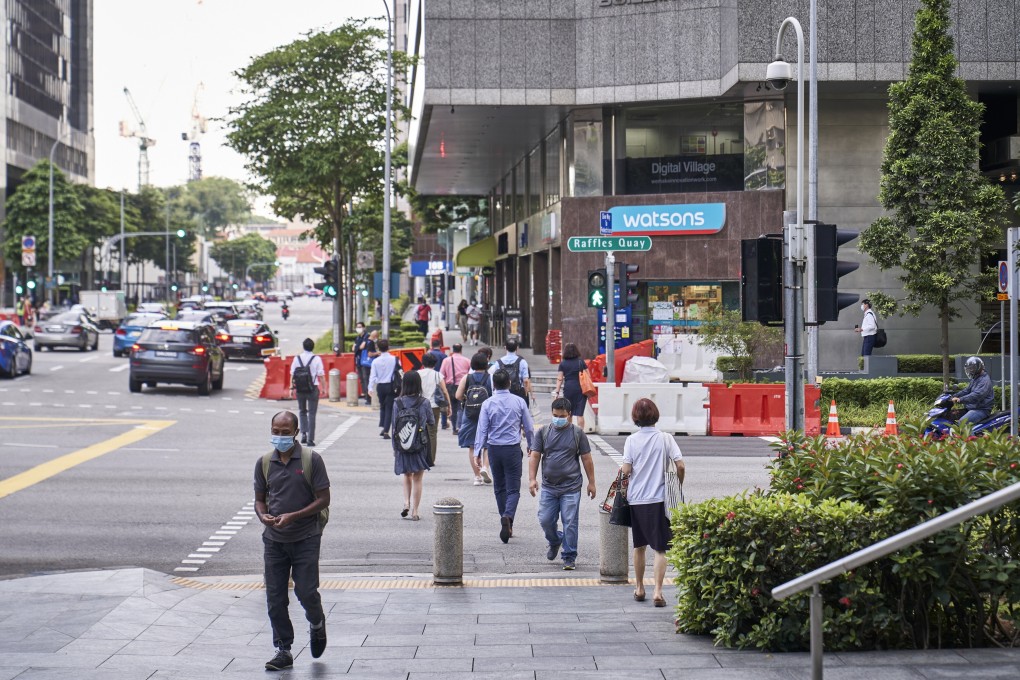 Pedestrians cross the street in the central business district of Singapore on Monday. Photo: Bloomberg