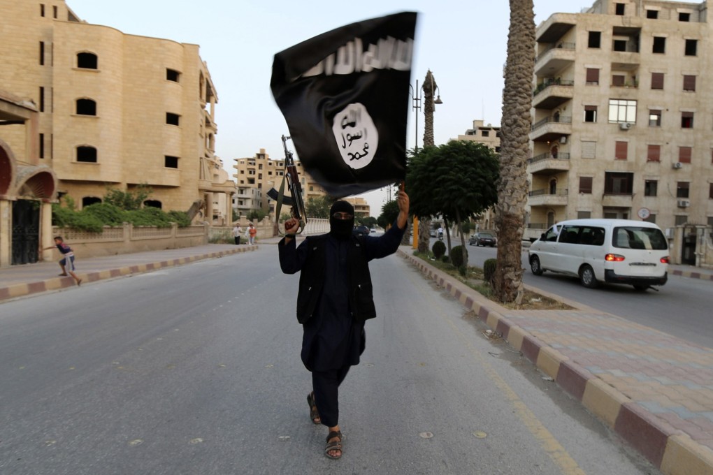 A member of Islamic State waves the group’s flag in Raqqa, Syria in June 2014. Photo: Reuters