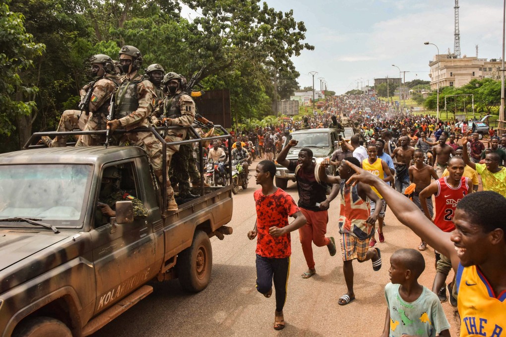 People celebrate in the streets with members of Guinea’s armed forces after the apparent arrest of president Alpha Condé in Conakry on Sunday. Photo: AFP