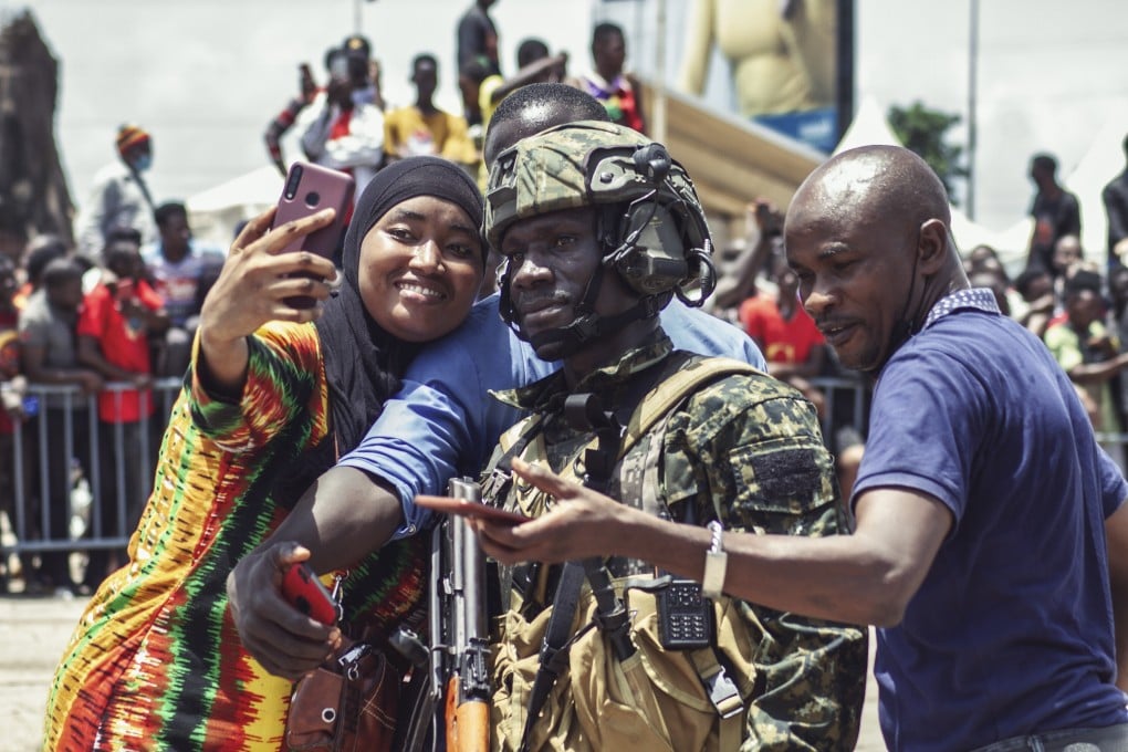 A woman takes a picture with Guinean special forces during celebrations at the Palace of the People in Conakry, Guinea. Phot: EPA