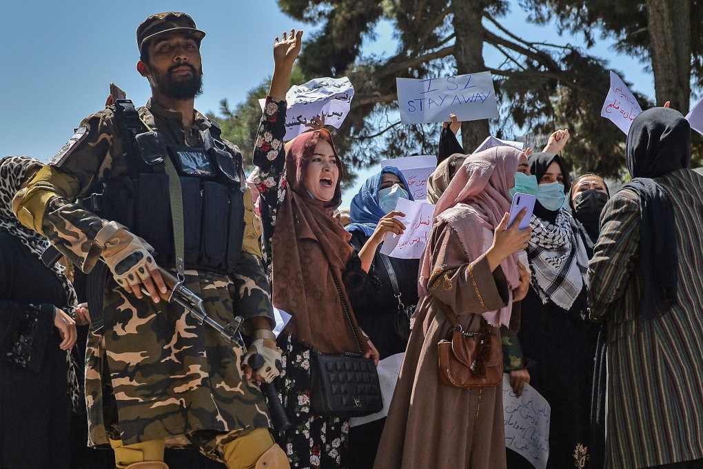 A Taliban fighter stands guard as Afghan women shout slogans during an anti-Pakistan protest rally, near the Pakistan embassy in Kabul. Photo: AFP