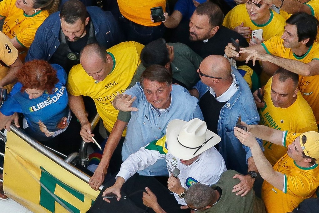 Brazilian President Jair Bolsonaro (centre) waves as he joins thousands of fans marching to show their support in Sao Paulo on Tuesday. Photo: AFP