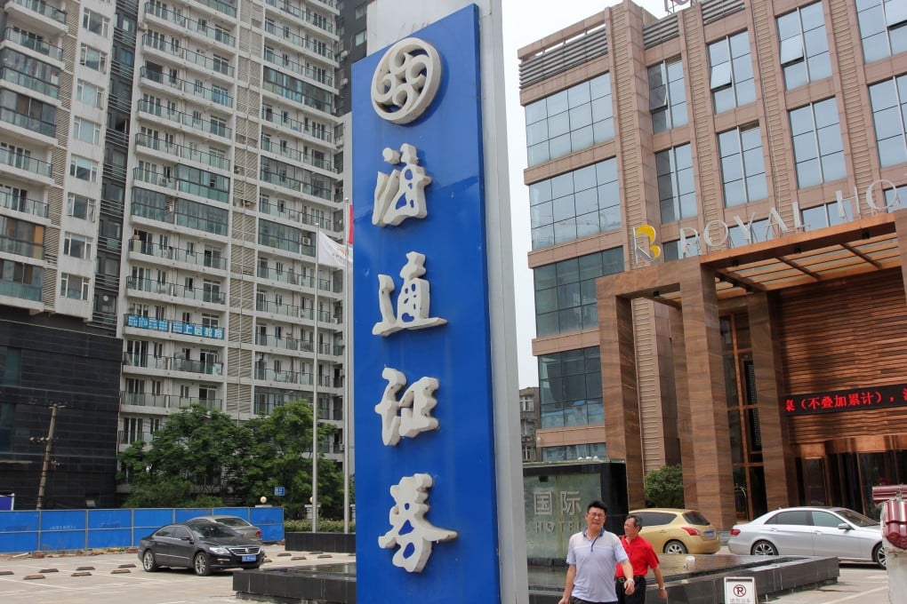 Pedestrians walk past a Haitong Securities signboard in Wuhan, central China’s Hubei province. Photo: Imaginechina via AFP