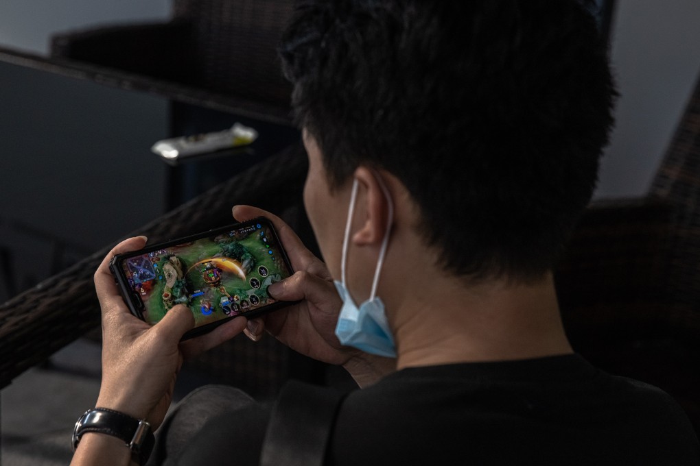 A man plays Honor of Kings game on his mobile phone in the shopping and residential area of Sanlitun, in Beijing, China, 25 August 2021. Photo: EPA-EFE