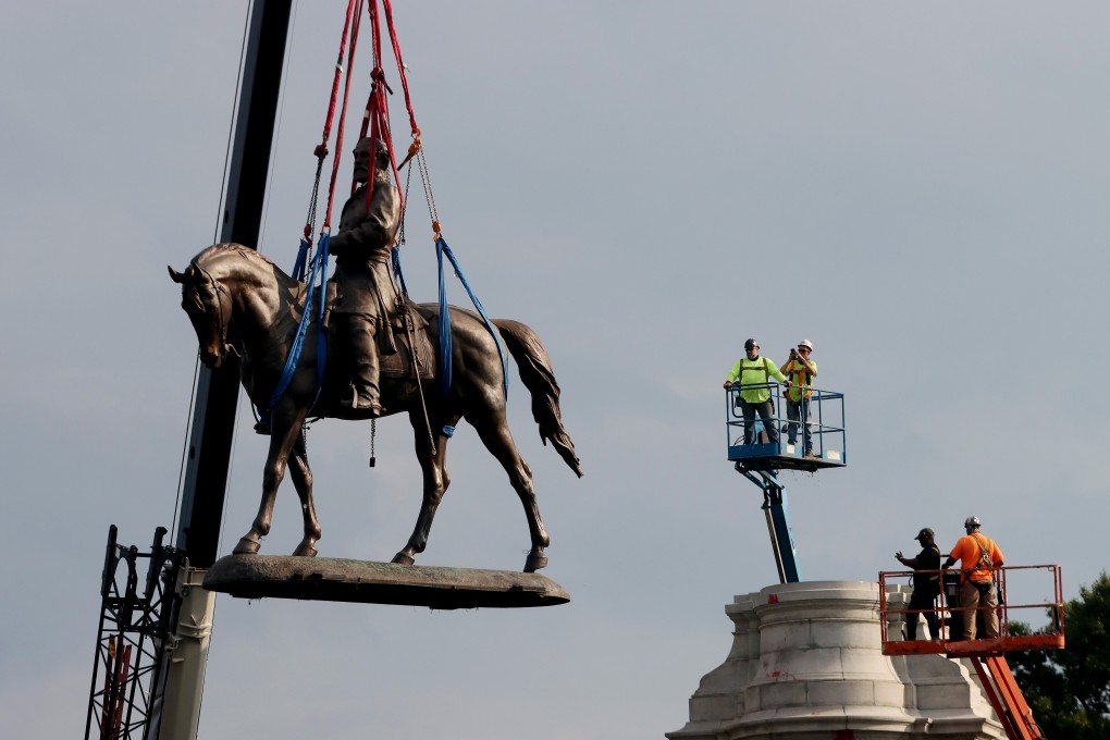 Workers take down the statue of Confederate General Robert E. Lee from its pedestal on Monument Avenue in Richmond, Virginia. Photo: DPA