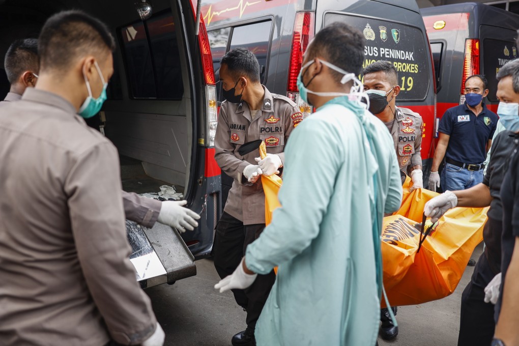 Indonesia police officers load a body bag into a van after the deadly fire at a prison in Tangerang. Photo: EPA