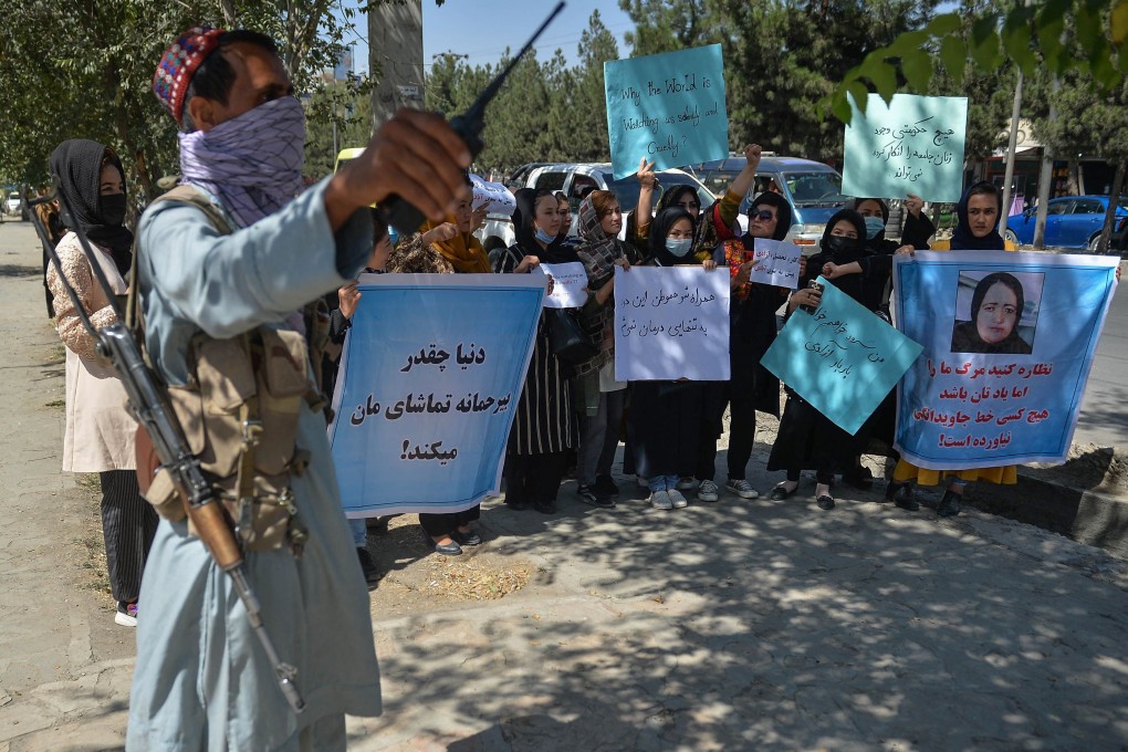 A Taliban fighter stands guard as Afghan women take part in a protest in Kabul on Wednesday. Photo: AFP