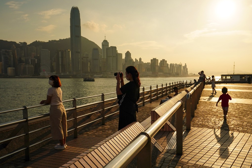 Hongkongers enjoy the sunset at the Tsim Sha Tsui waterfront after the city’s Observatory downgraded the chances of issuing a typhoon warning on Thursday. Photo: Felix Wong