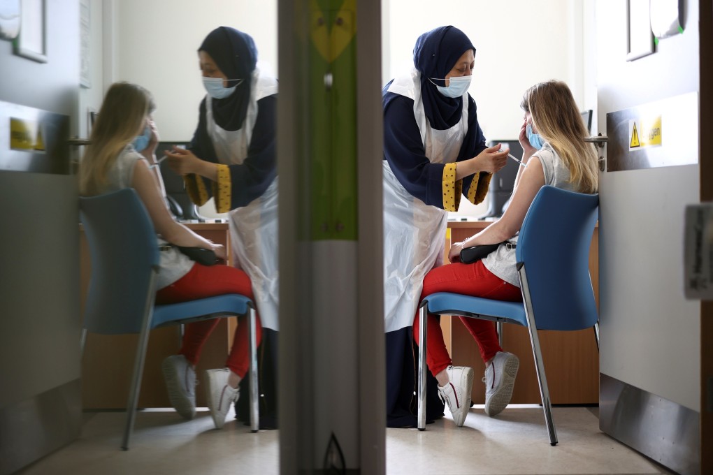A woman receives a dose of the Pfizer Covid-19 vaccine at a hospital in London. Photo: Reuters