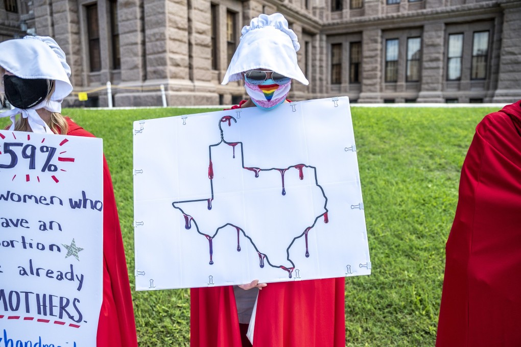 A protester dressed as a handmaid holds up a sign outside the Texas state capitol in Austin in May. Photo: TNS