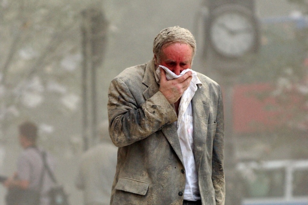 Edward Fine covers his mouth as he walks through dust and debris following the collapse of one of the twin towers on September 11, 2001. File photo: AFP