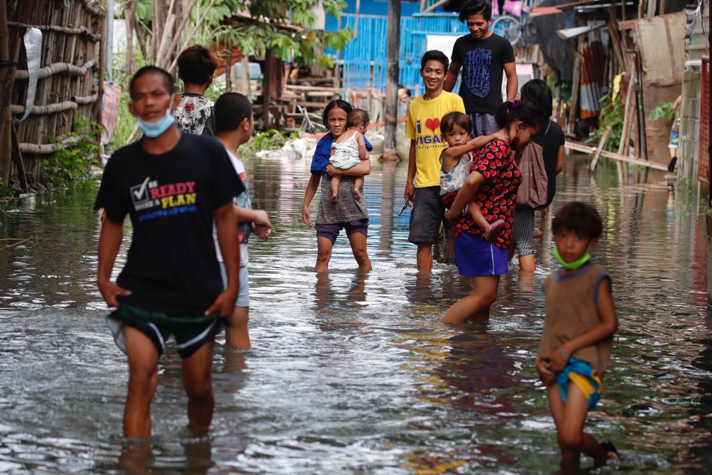 Villagers wade though floodwaters after the Philippines was hit by two major tropical storms in a week. Photo: EPA-EFE