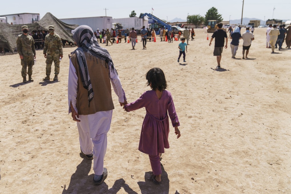 A man walks with a child through Doña Ana Village in Fort Bliss. Photo: AP