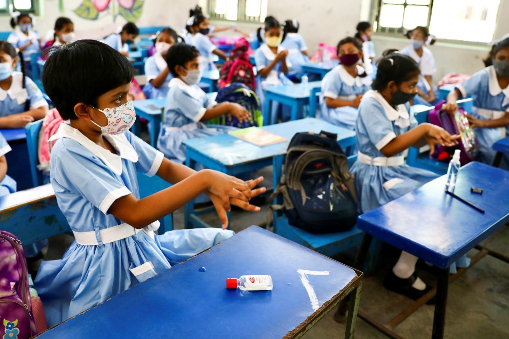 Pupils apply hand sanitiser while attending a class in Dhaka on Sunday as schools in Bangladesh reopened after nearly one and a half years of closure. Photo: Reuters