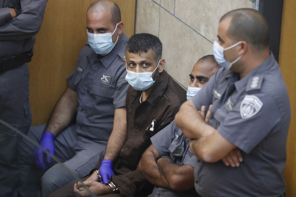 Palestinian militant Mohammad Ardah, one of the six militants who escaped from a high-security prison, with Israeli police officers during his trial in Nazareth, Israel on Saturday. Photo: AFP