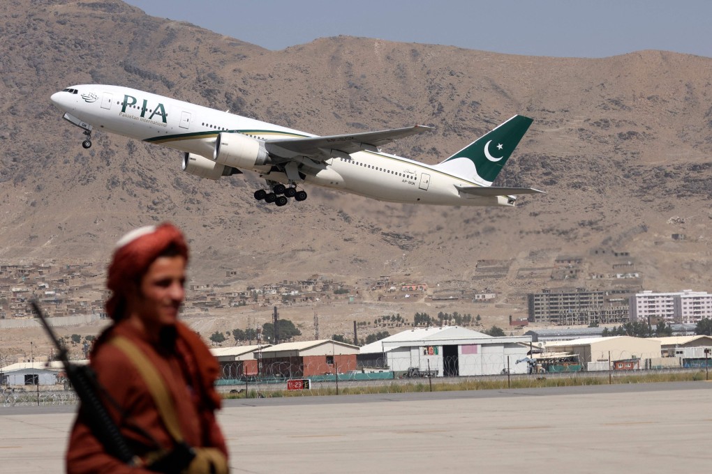 A Taliban fighter stands guard as the first commercial international flight since the group retook power last month takes off from the airport in Kabul on Monday. Photo: AFP