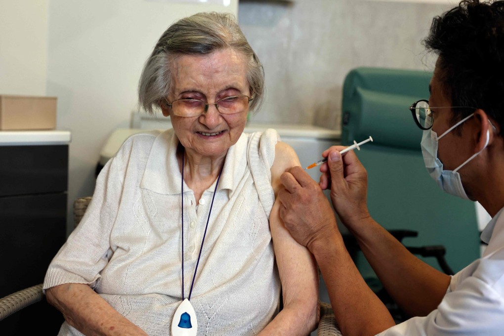 An elderly patient receives a booster shot of the Pfizer-BioNTech Covid-19 vaccine in Paris on Monday. Photo: AFP