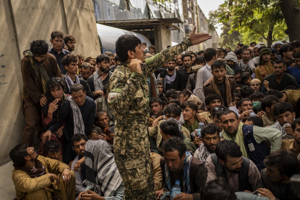 Afghans wait in front of a bank as they try to withdraw money in Kabul. Photo: AP