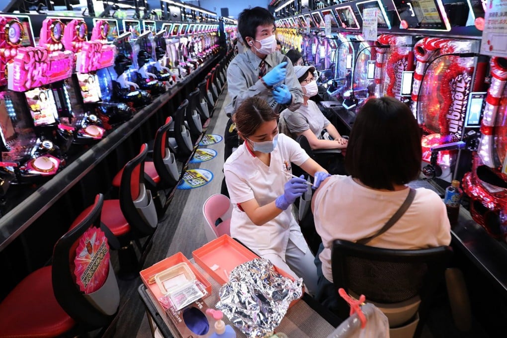 A health worker administers a dose of Covid-19 vaccine to a person in a pachinko arcade in Osaka on Tuesday. Photo: AFP