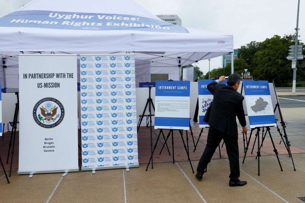 Dolkun Isa, president of the World Uygur Congress, puts the final touches on a photo exhibit in front of the United Nations in Geneva on Friday. Photo: Reuters