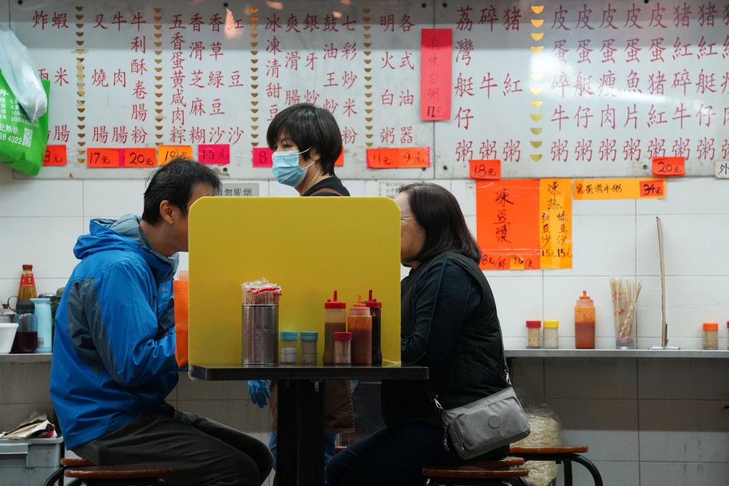 People dine at a table with a partition board inside a restaurant in Hong Kong on December 8, 2020. Photo: Reuters