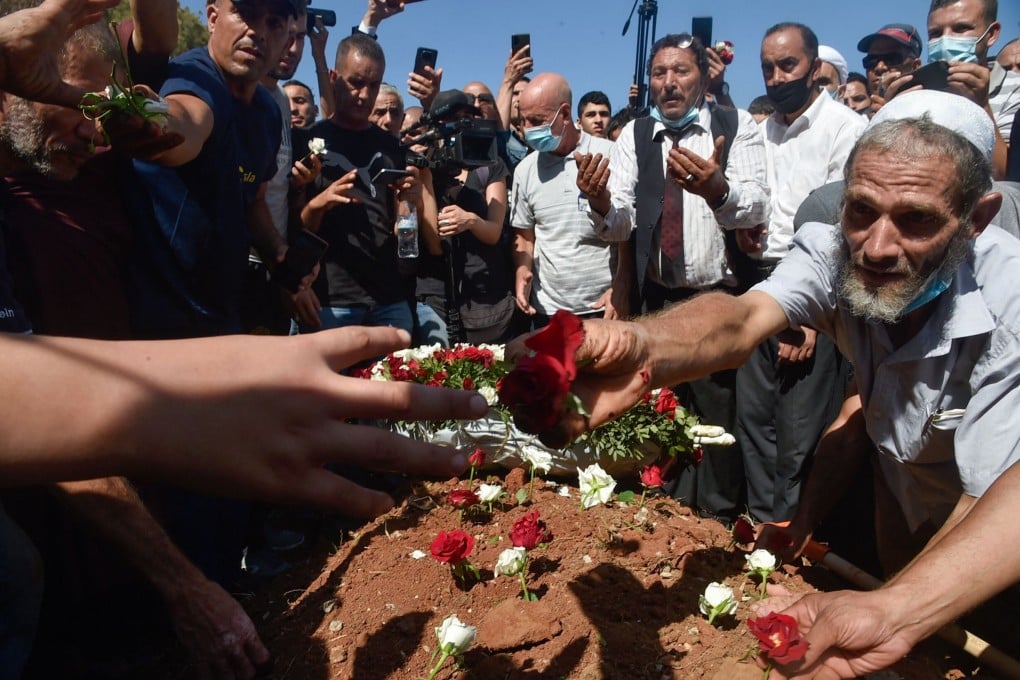 Algerians place roses on the tomb of former president Abdelaziz Bouteflika during his funeral at the El-Alia cemetery in Algiers on Sunday. Photo: AFP