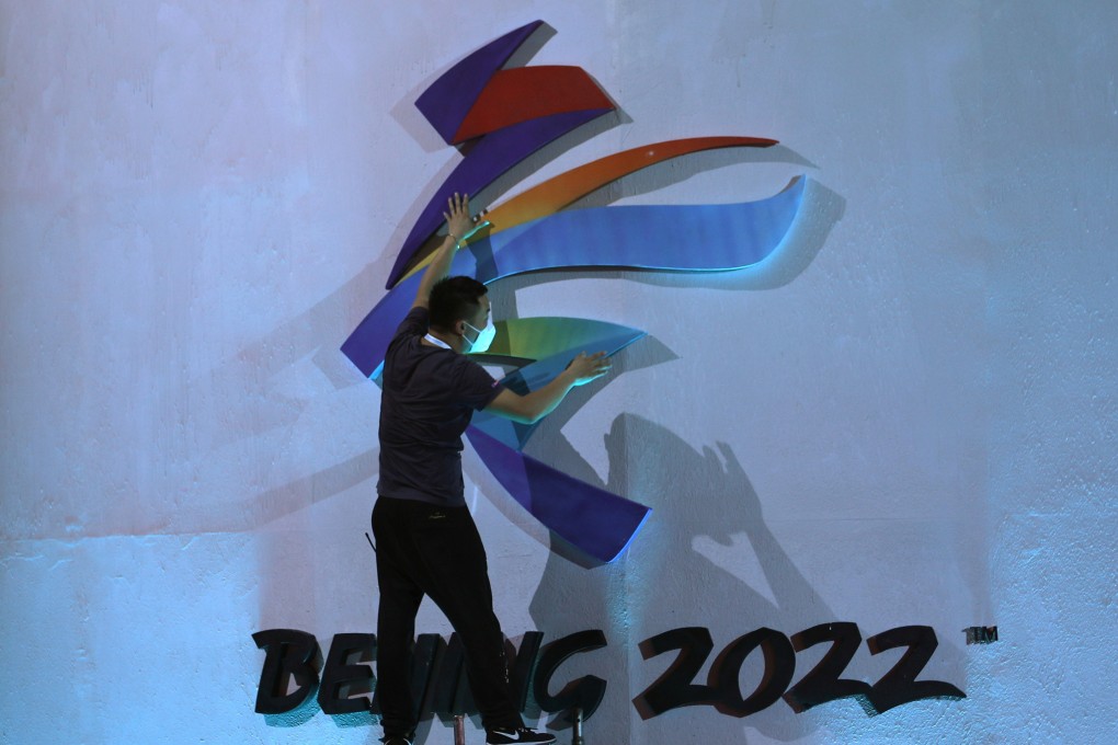 A man adjusts an emblem of the Beijing 2022 Winter Olympic Games before a ceremony unveiling the slogan, in Beijing on September 17, 2021. Photo: Reuters