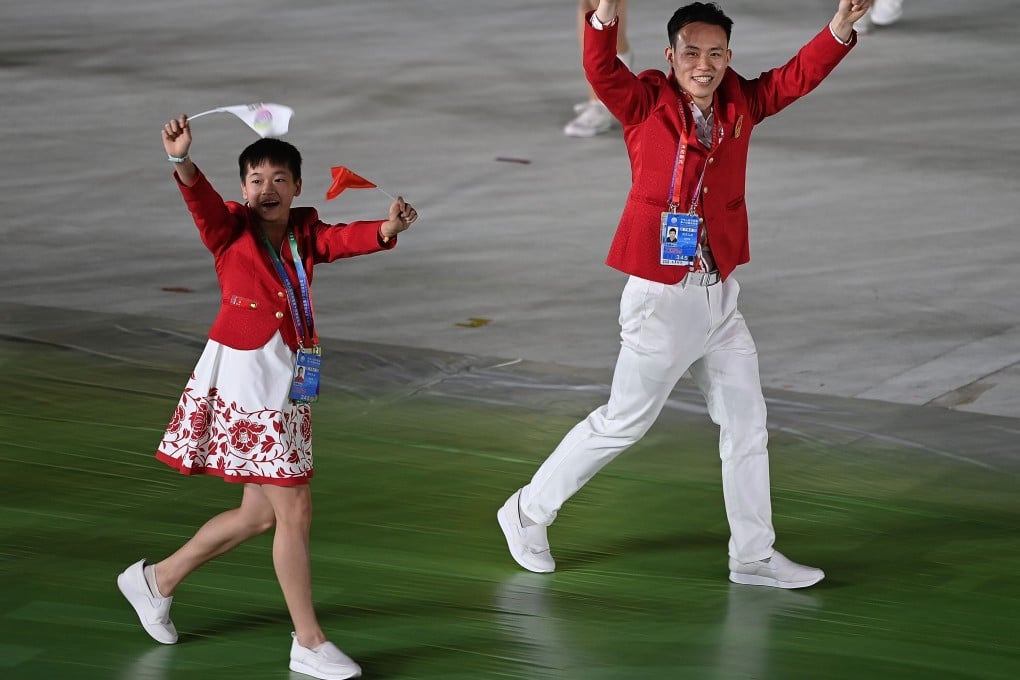 Quan Hongchan (left) and fellow diver Xie Siyi take part in the parade into the stadium during the opening ceremony for China’s 14th National Games in Xian, Shaanxi province. Photo: Xinhua