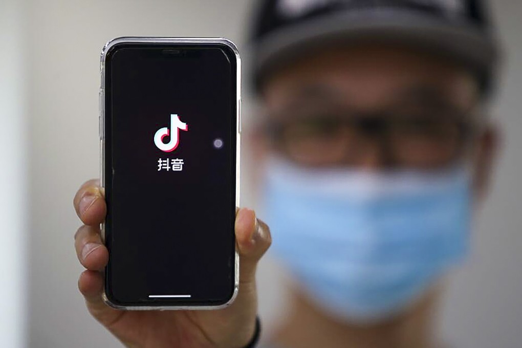 A user of Douyin holds up the splash screen of the app. The Chinese version of TikTok is limiting users under the age of 14 to just 40 minutes per day following recent time limits imposed on video games for children. Photo: Weibo