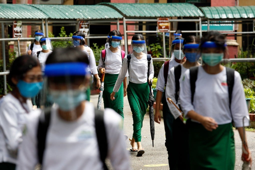Students wearing masks and face shields leave after attending the first day of school in Yangon, Myanmar. Photo: AFP