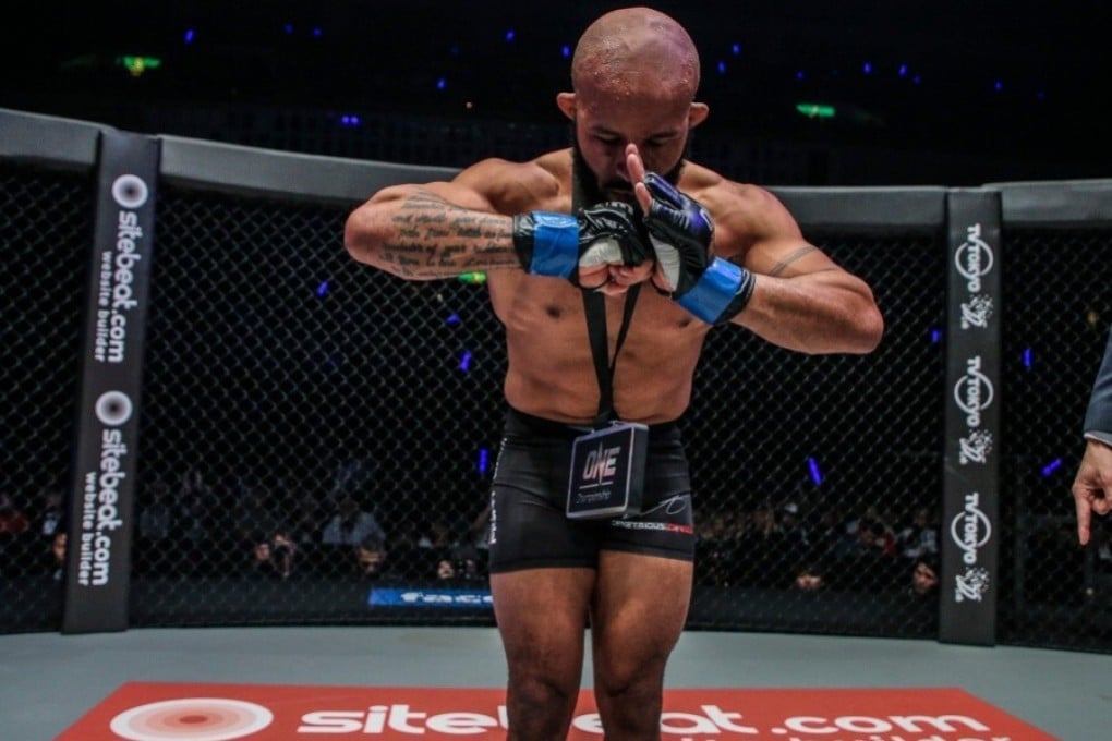 Demetrious Johnson bows in celebration after victory on his ONE Championship debut. Photos: ONE Championship