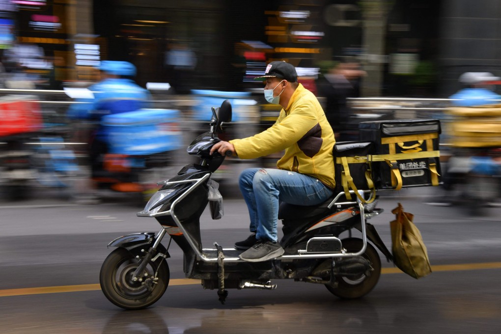 A delivery rider for Meituan, one of China's biggest food delivery firms, making a delivery after picking it up at a restaurant in Beijing on April 27. Photo: AFP