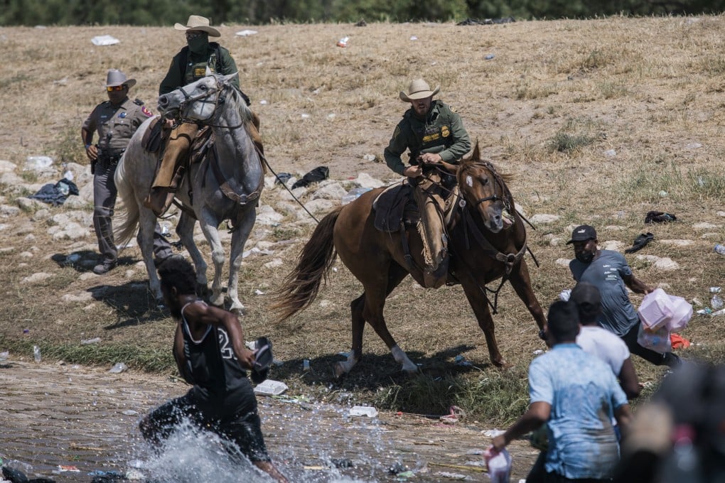 US Customs and Border Protection mounted officers attempt to contain migrants as they cross the Rio Grande from Mexico into Del Rio, Texas, on Sunday. Photo: AP