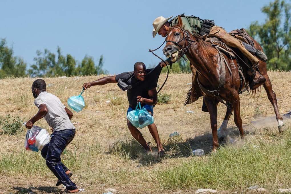 US Border Patrol agent on horseback tries to stop a Haitian migrant from entering an encampment on the banks of the Rio Grande in Del Rio, Texas, on Sunday. Photo: AFP
