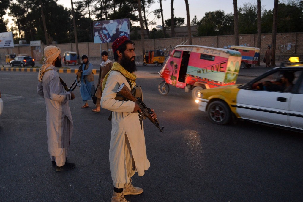 Taliban fighters stand guard along a road in Herat, Afghanistan. Photo: AFP