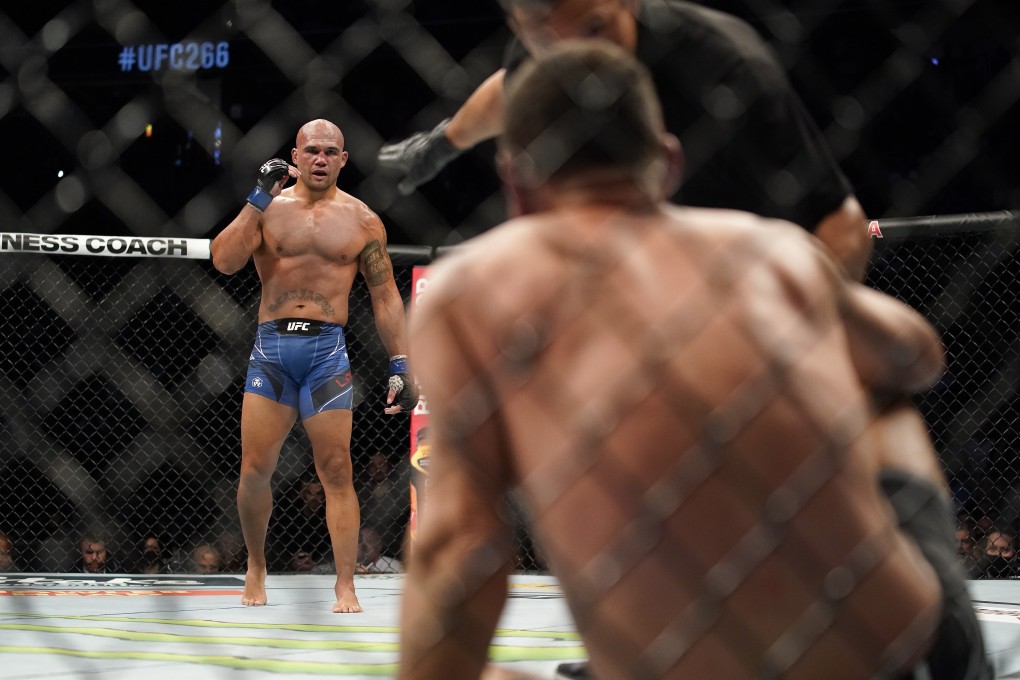 Robbie Lawler looks on as referee Jason Herzog checks on Nick Diaz. Photo: AP