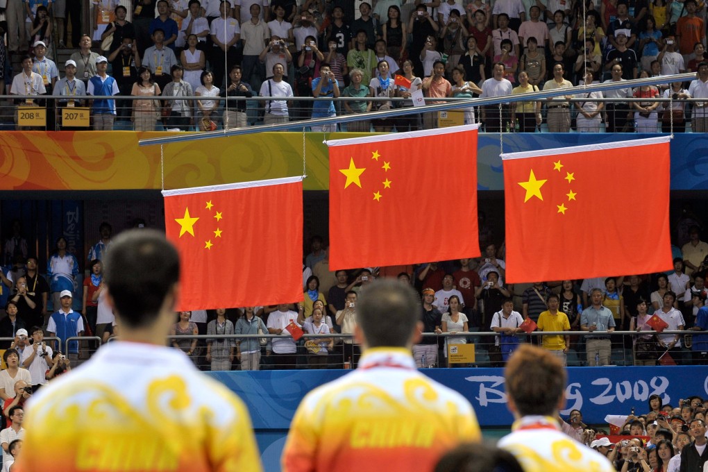 Chinese medallists (from left) Wang Liqin, Ma Lin and Wang Hao stand at attention for the national anthem during the awards ceremony for men’s singles table tennis, at the Beijing Olympic Games on August 23, 2008. Ma won gold, defeating Wang Hao who took silver, while Wang Liqin took bronze. Photo: AFP