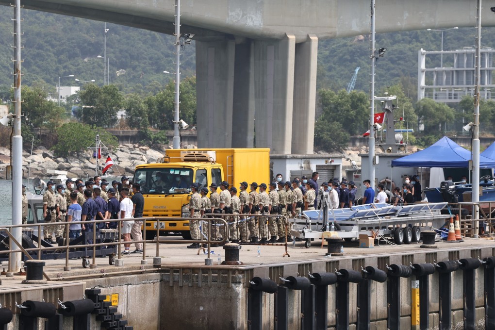 Officers stand at attention as the body of senior inspector Lam Yuen-yee is placed inside a yellow government vehicle on Monday. Photo: K. Y. Cheng