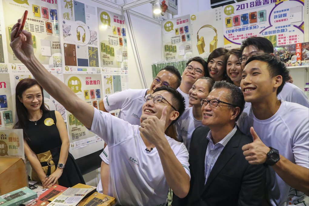 Financial Secretary Paul Chan (in black jacket) poses for a selfie with a group of admirers at the Hong Kong Book Fair. Photo: K. Y. Cheng