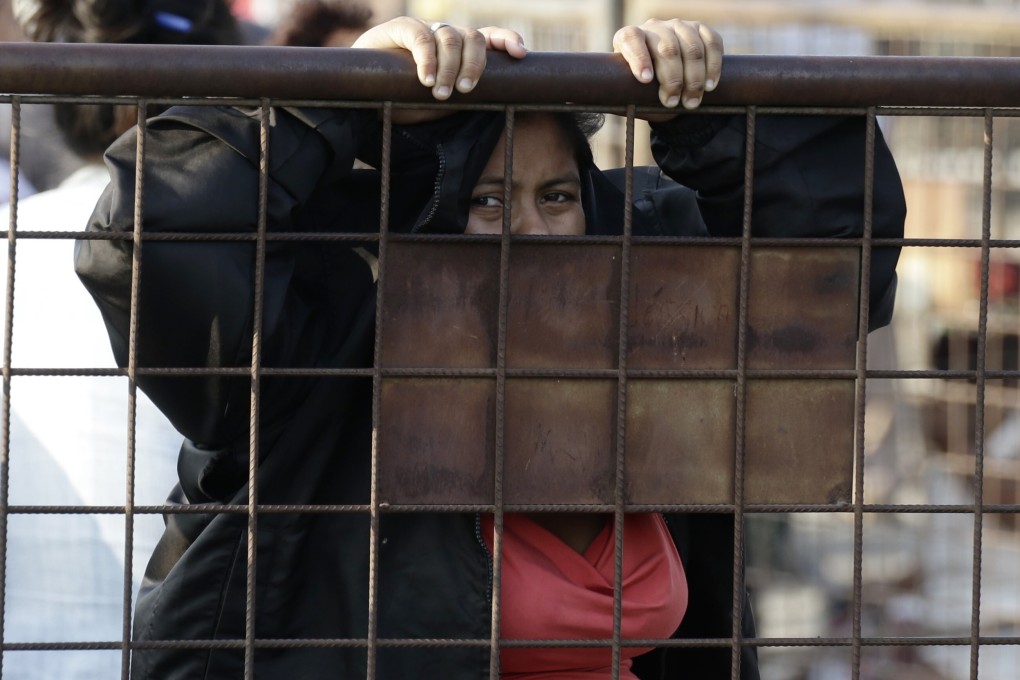 A relative of an inmate awaits news outside the prison. Photo: AP