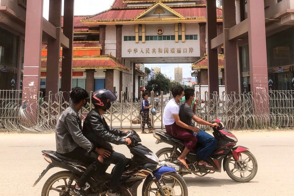 Motorists on the Myanmar side of the border pass a locked gate that leads to Ruili. Photo: STR/ AFP